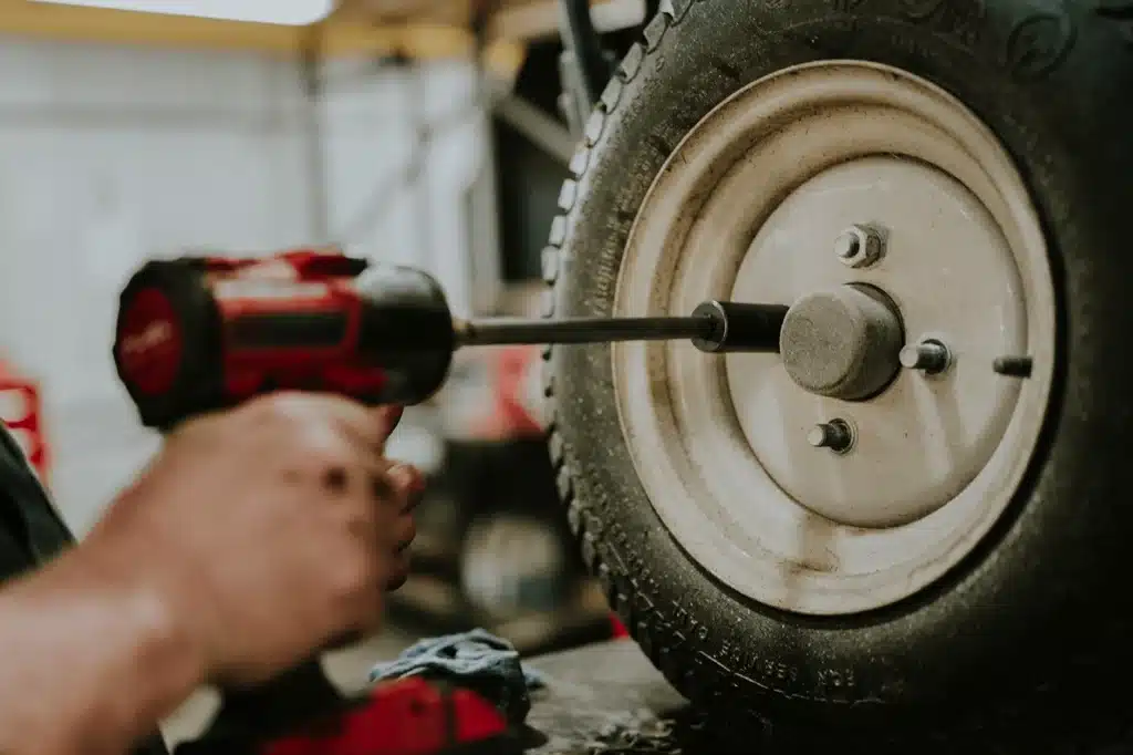 Technician repairing tire during commercial lawn mower maintenance